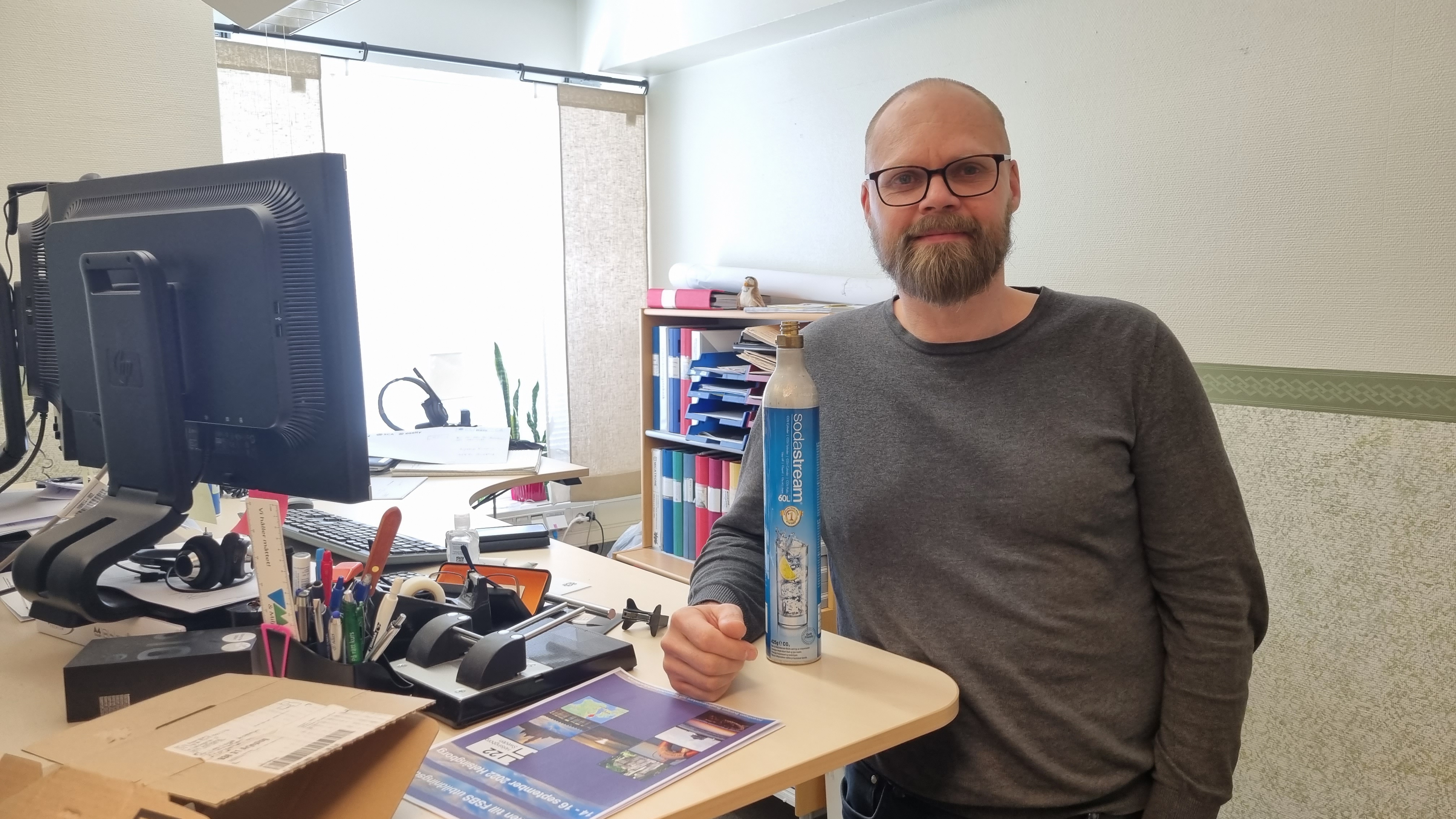 Emil Sundström på sitt kontor, med en kolsyrepatron ståendes på bordet.