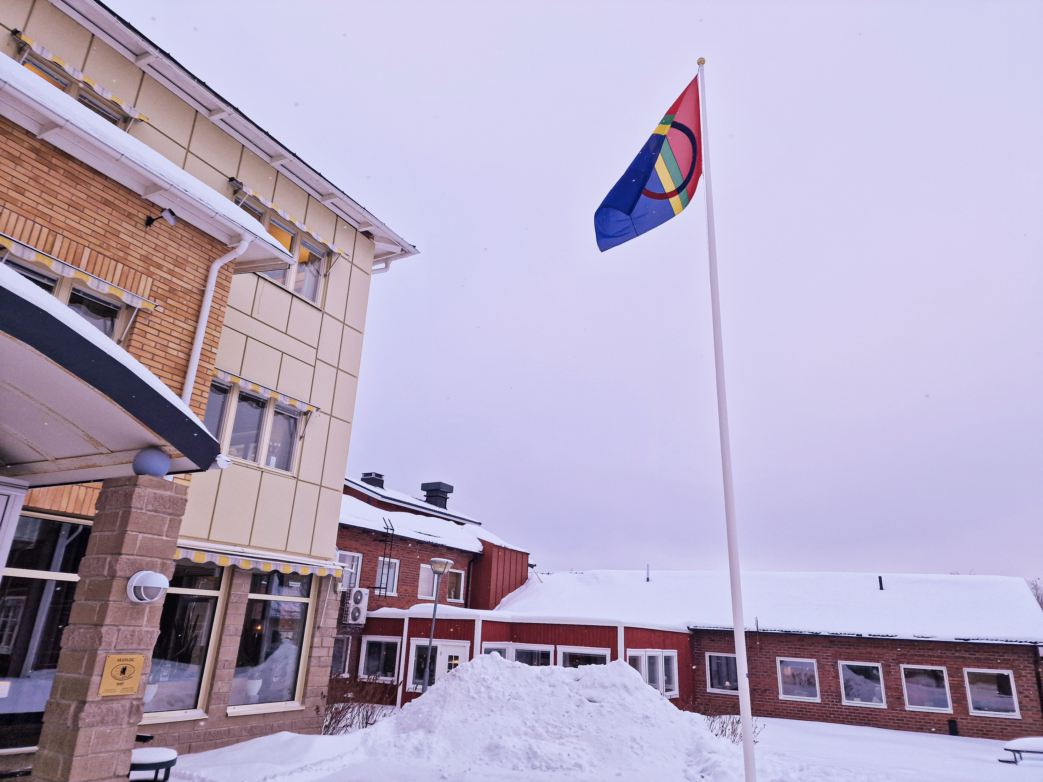 Den samiska flaggan vajar utanför kommunhuset en mulen vinterdag.