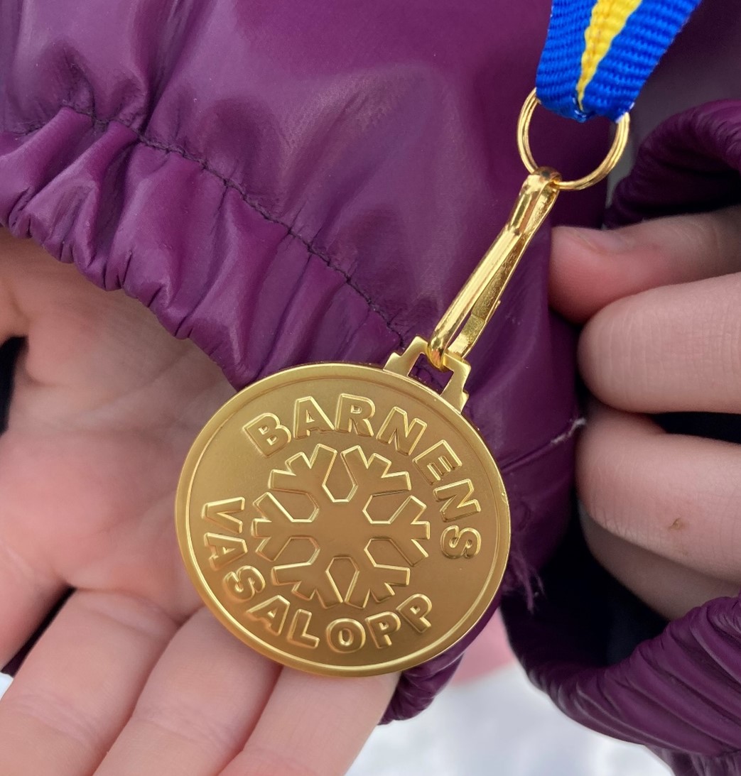 En medalj till synes gjord av guld som det står Barnens vasalopp på.