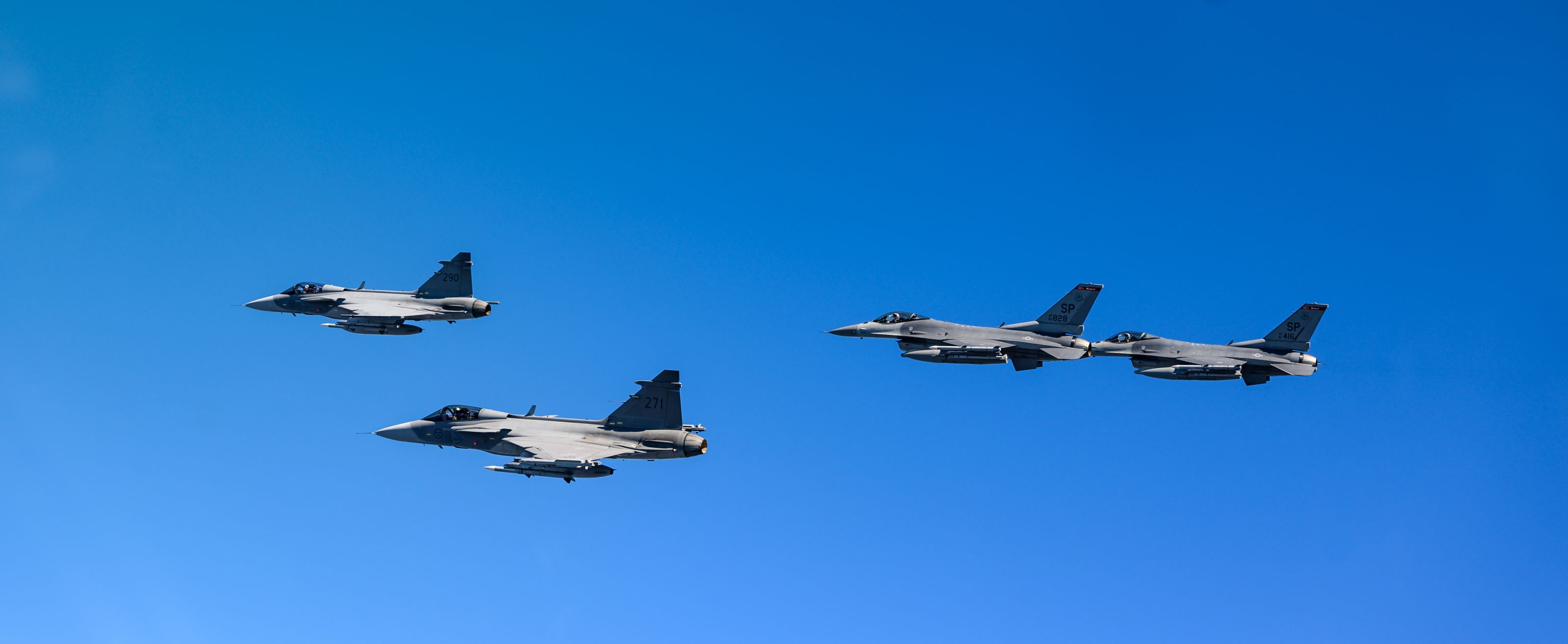 Fyra stridsflygplan i formation i luften.