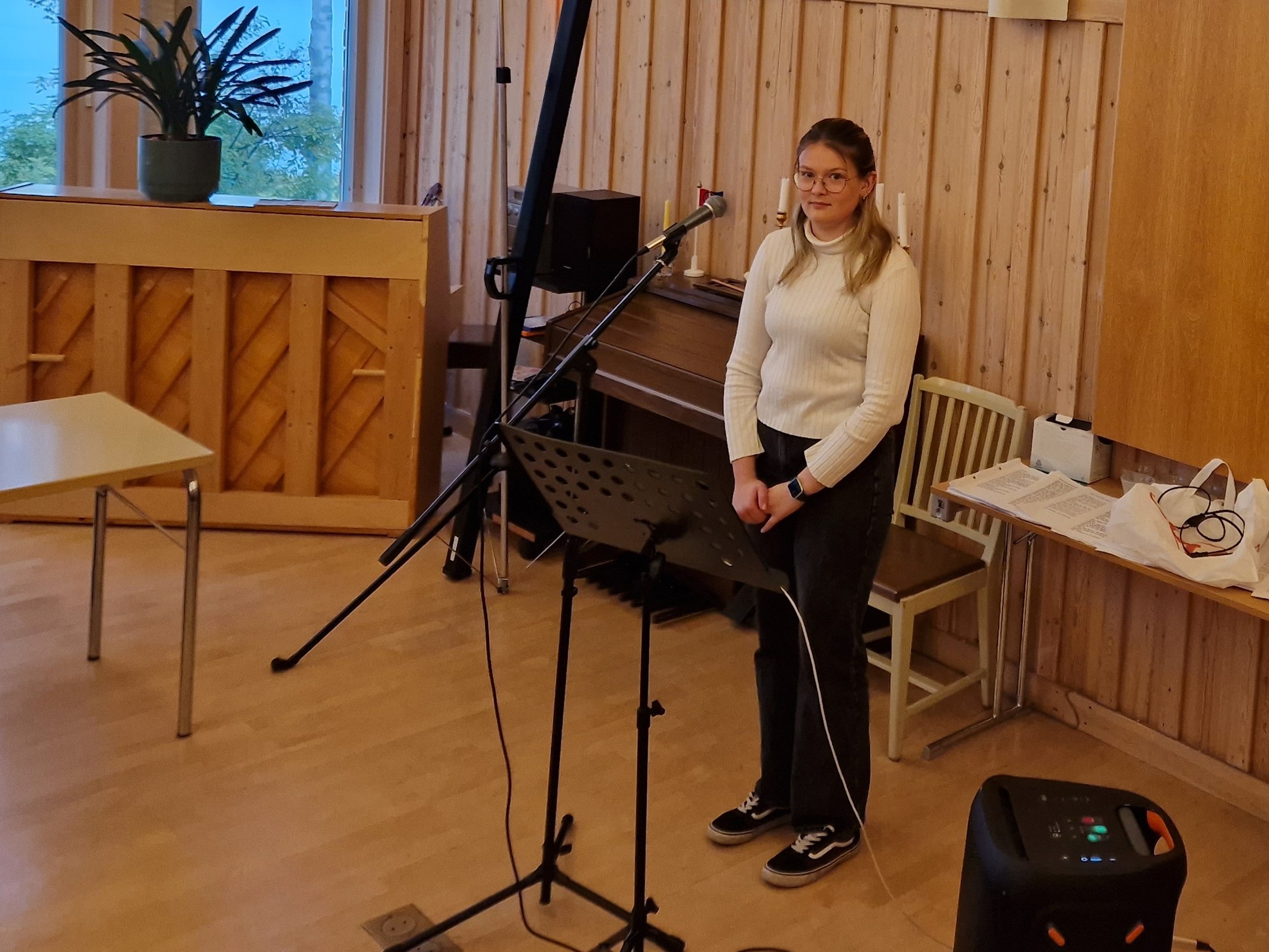 Elsa Nordlund Kvael  framför mikrofonen i Vaukagårdens samlingssal