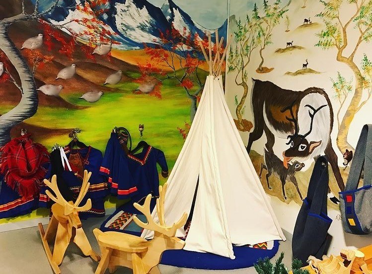 Foto på en lokal i förskolan med väggar målade med fjällmotiv, två gunghästar i form av renar och en liten tältkåta som barnen kan leka i.